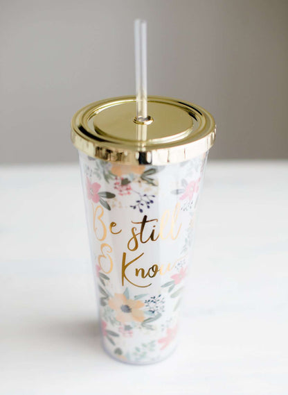 Be still and know double wall tumbler. This tumbler has flowers adorning it and accented with a gold cap and gold writing.