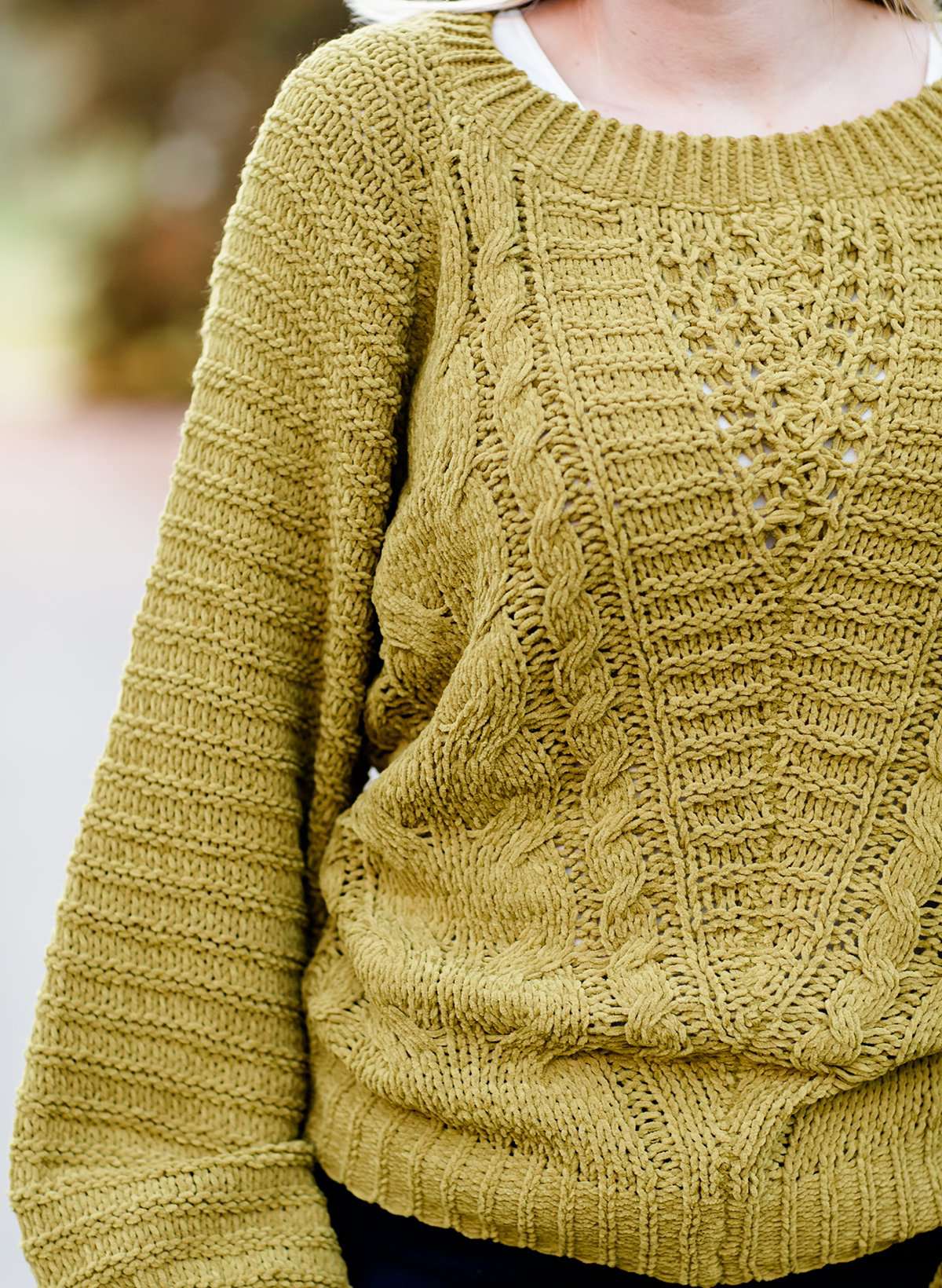 Young woman wearing a balloon sleeve chenille like sweater with a below the knee navy midi skirt