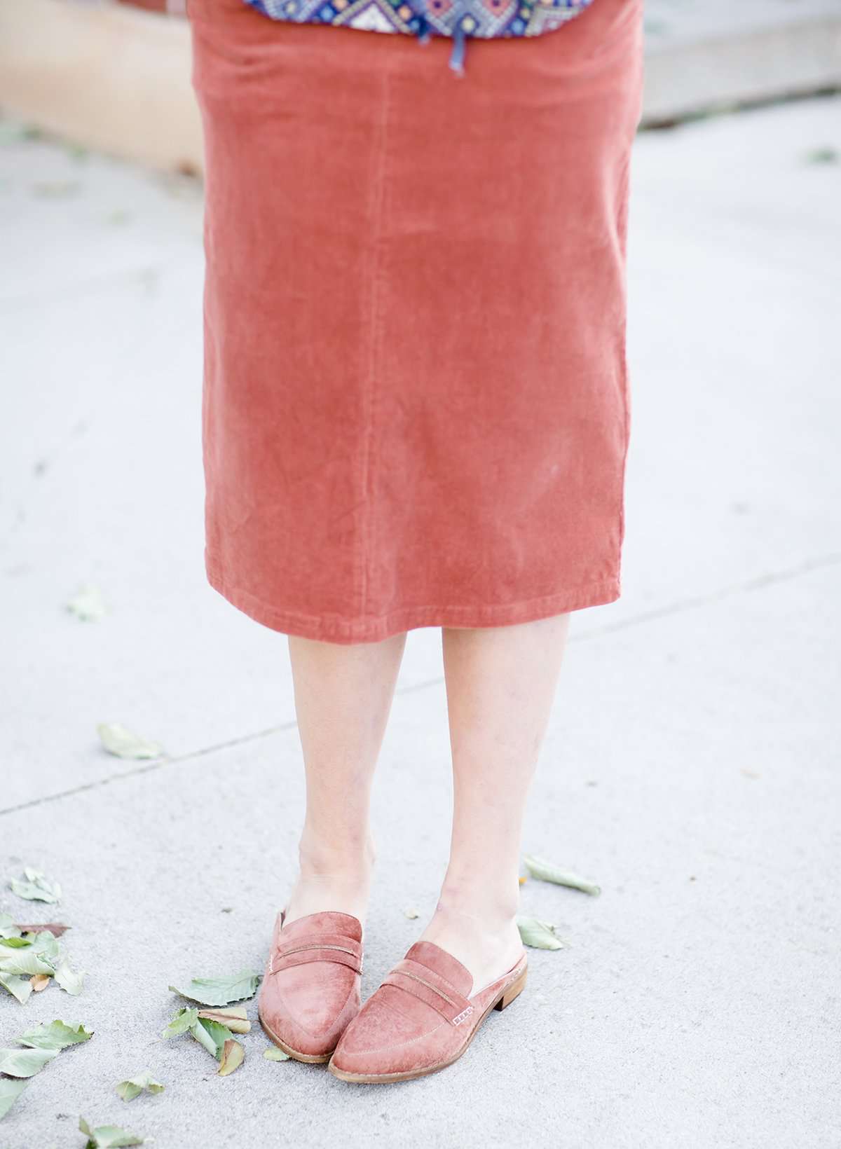 Woman wearing a classic copper colored backless genuine leather loafer