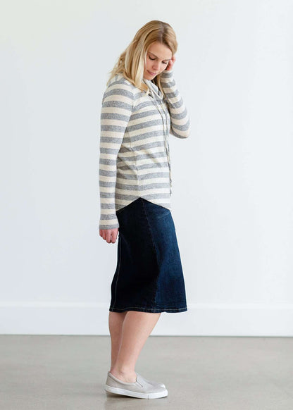 Woman wearing a modest gray and white striped cowl neck pullover top.