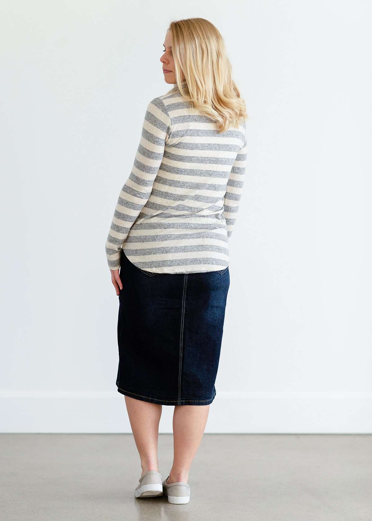 Woman wearing a modest gray and white striped cowl neck pullover top.