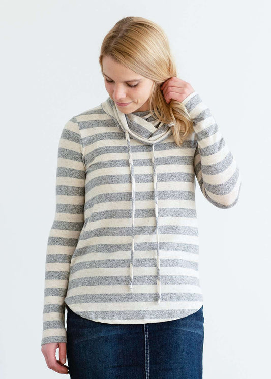 Woman wearing a modest gray and white striped cowl neck pullover top.