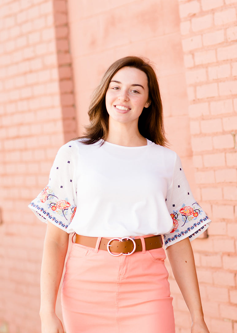 White top with multi color floral embroidered knit sleeves