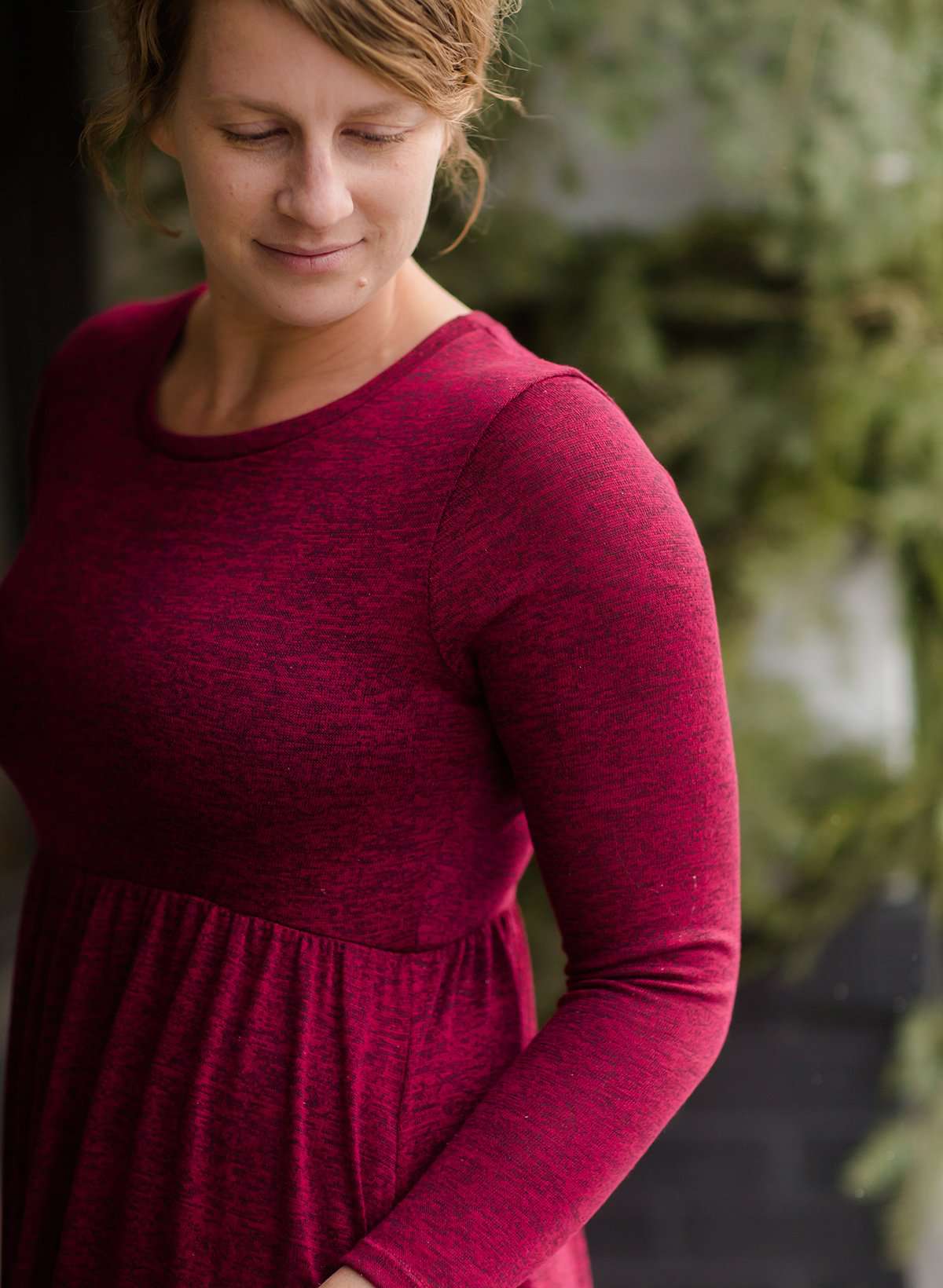 Woman wearing a wine colored maxi dress made of a hacci material standing outside of Inherit Clothing Company