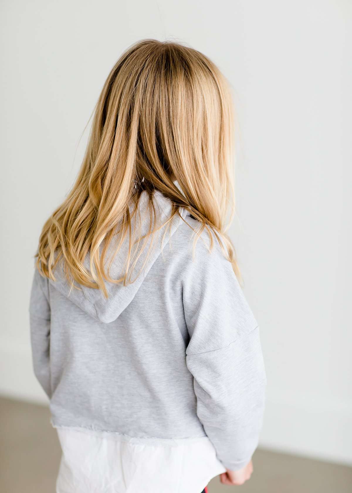 Girl wearing a french terry hoodie with a white button shirt underlay