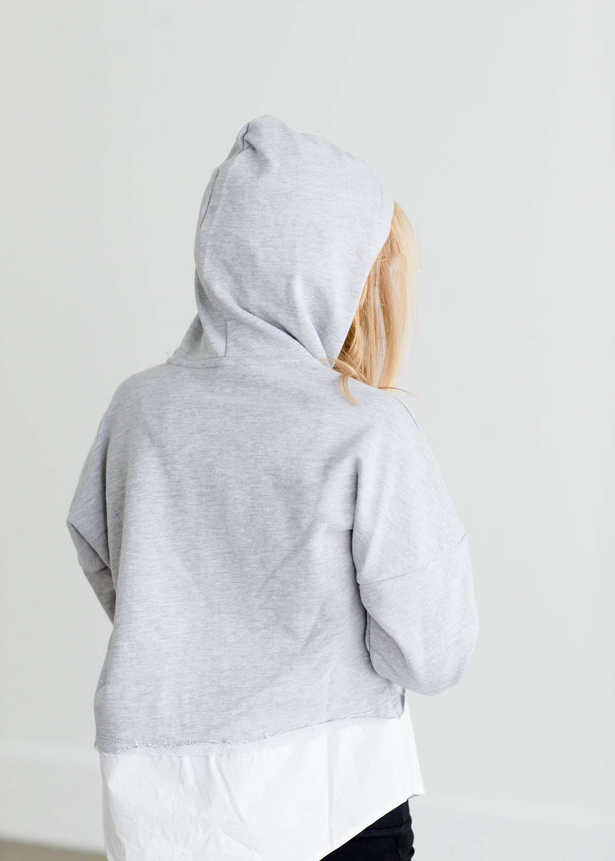 Girl wearing a french terry hoodie with a white button shirt underlay